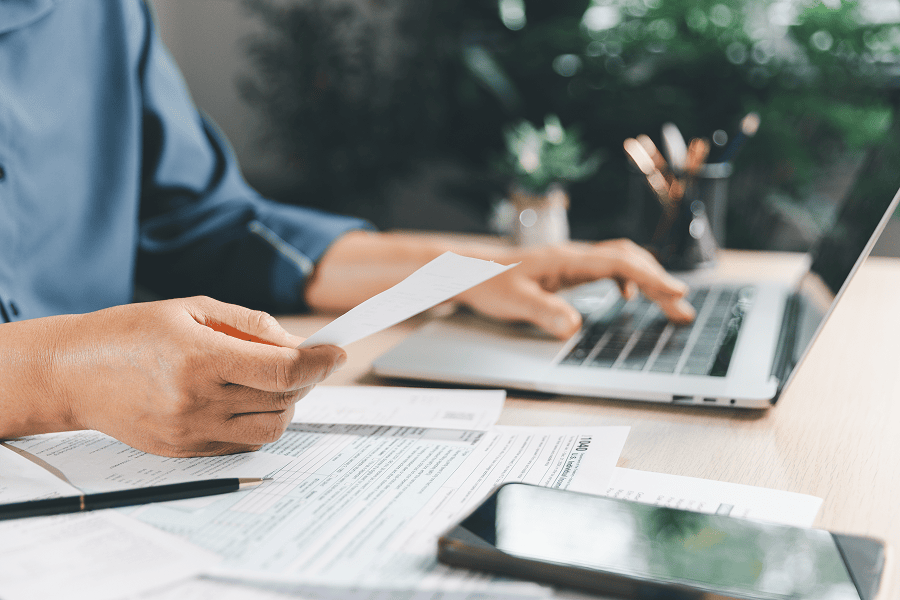 man holding paper while typing