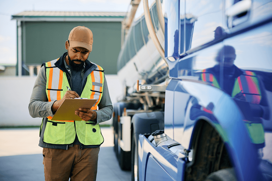 Man checking vehicle maintenance checklist.