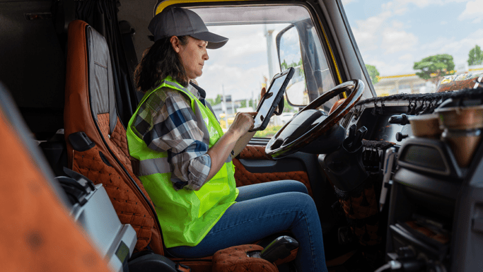 Woman looking at tablet inside truck