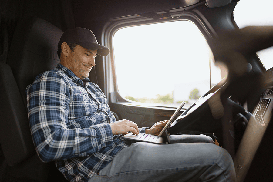 Man sitting in truck while looking at laptop